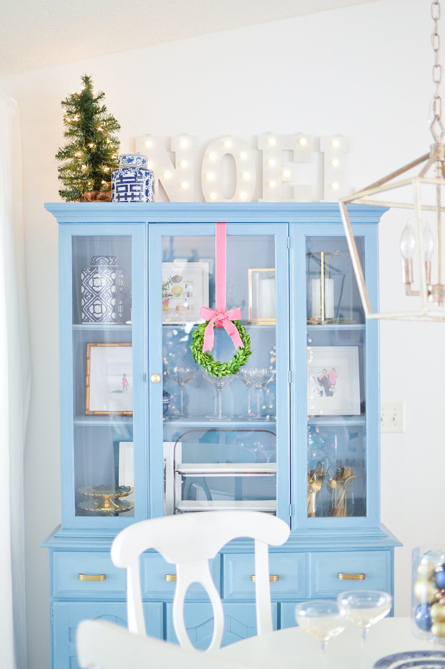 blue hutch, noel marquee, mini Christmas tree, chinoiserie holiday decor, boxwood wreath, white walls, modern colorful Christmas kitchen on Megan Martin Creative 
