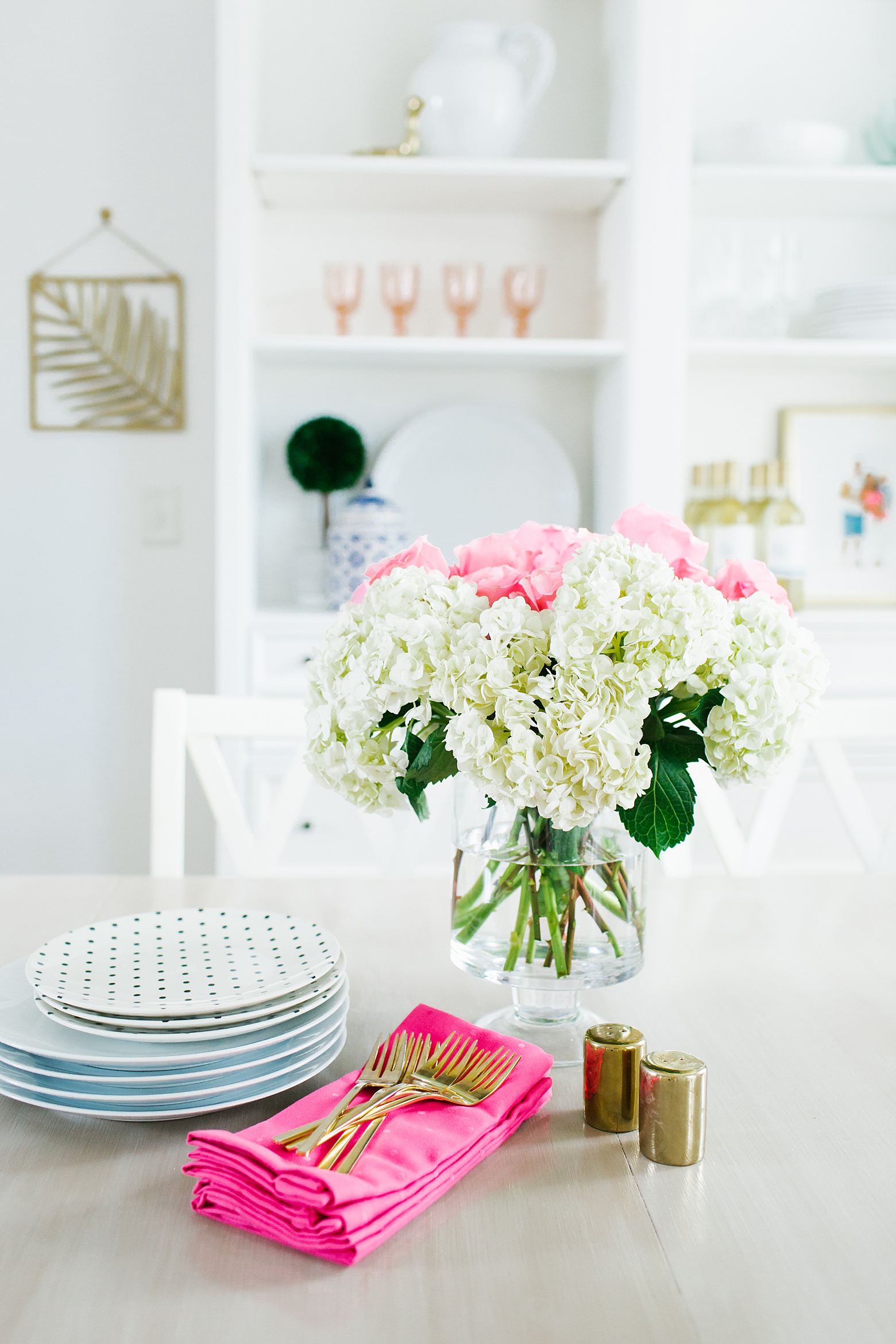 A Bright and Colorful Dining room in Florida, kate spade dinnerware, gold flatware, pink napkins, shelfie, design by Megan Martin Creative