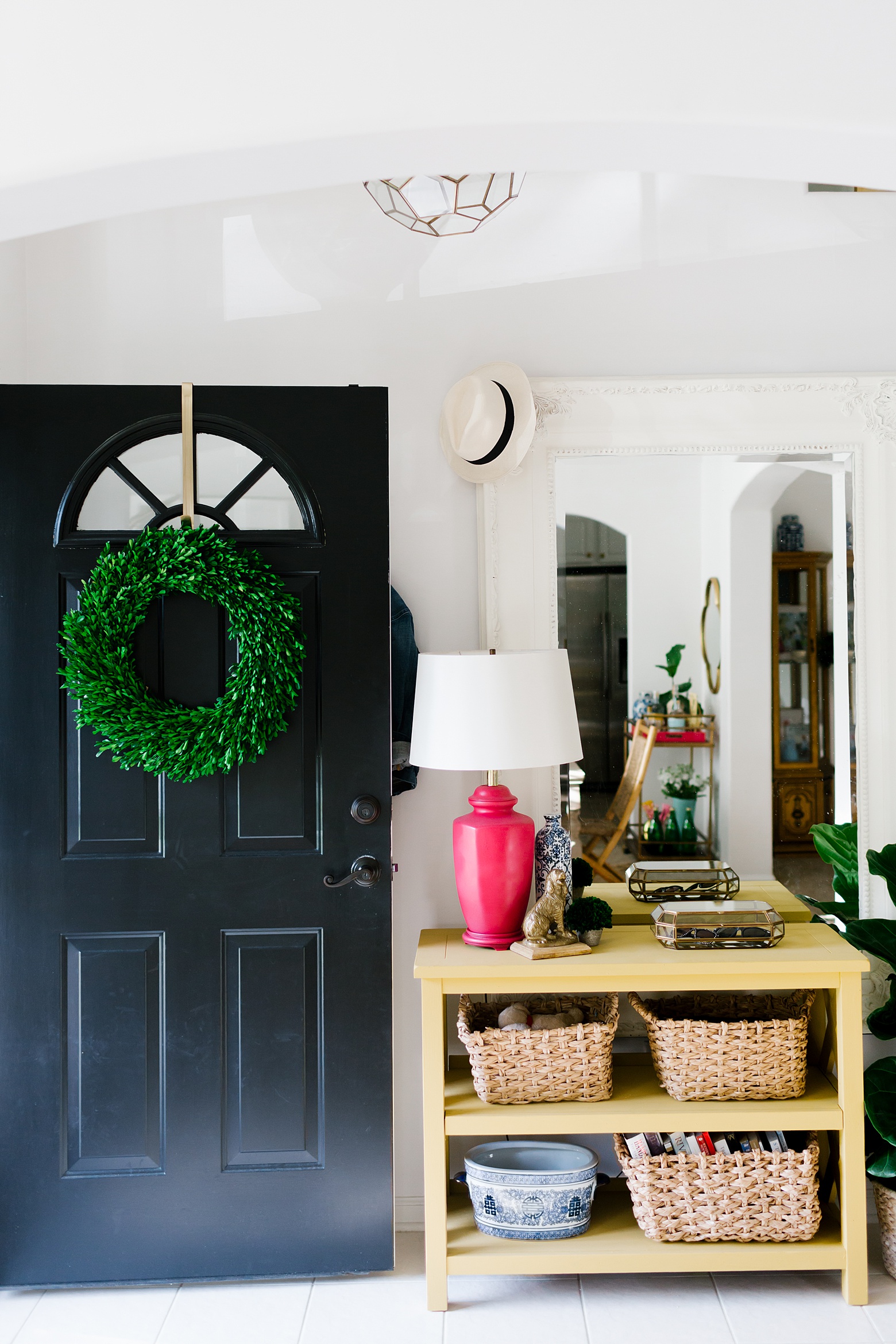 A colorful entryway for this bright home, boxwood wreath, white walls, faceted glass and brass pendant light, modern home decor, colorful home design on Megan Martin Creative
