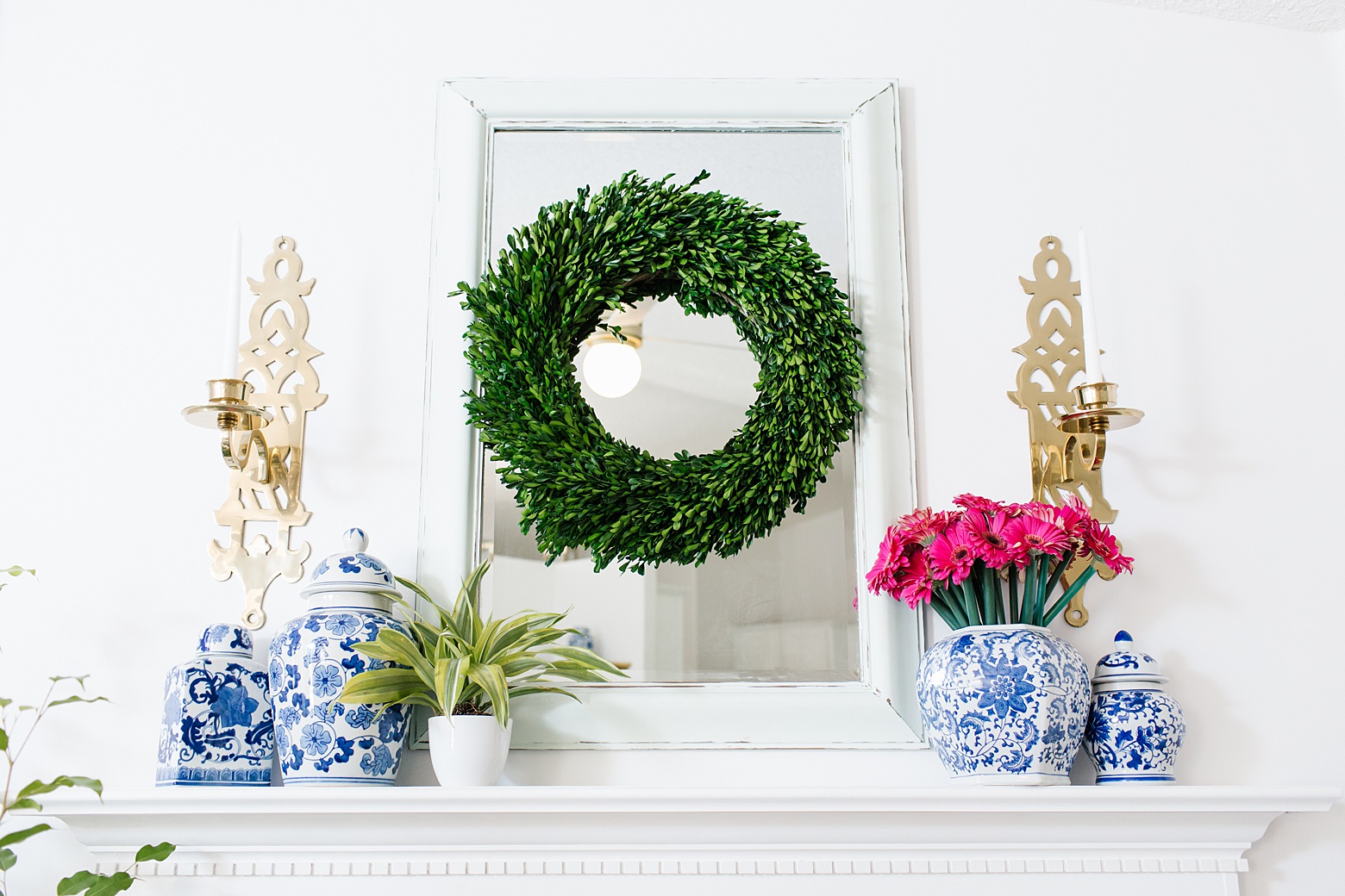 bright and colorful living room, chinoiserie, blue and white jars, wreath on mirror, mantel designed by Megan Martin Creative