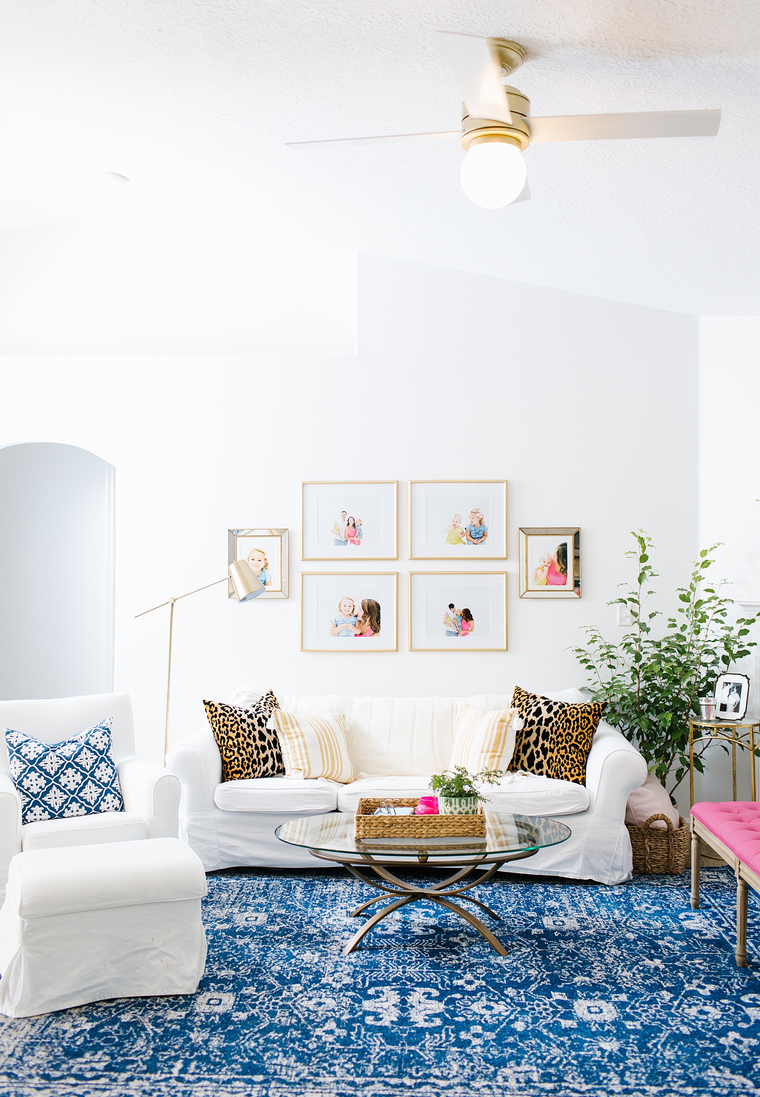 navy, white, pink, and green open bright and colorful living room design by Megan Martin Creative. Navy and white rug, photo gallery wall, family friendly home