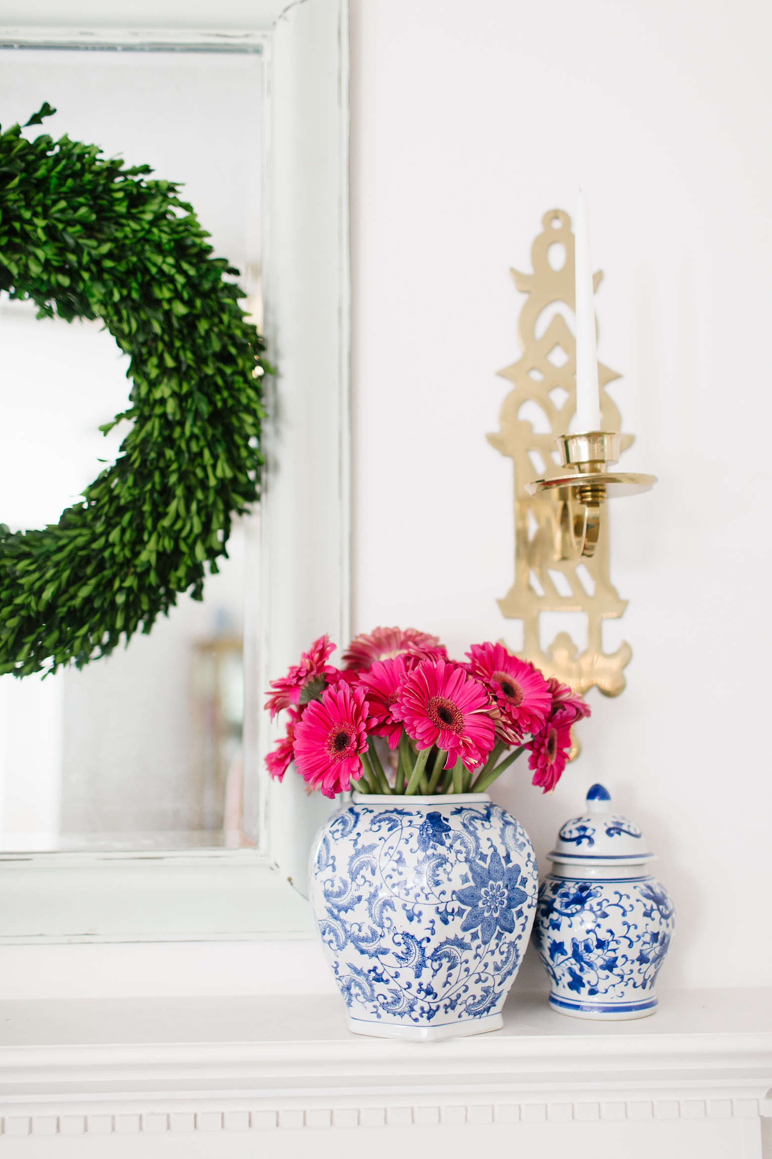 mantel decorations, blue and white jars, boxwood wreath, bright and colorful living room